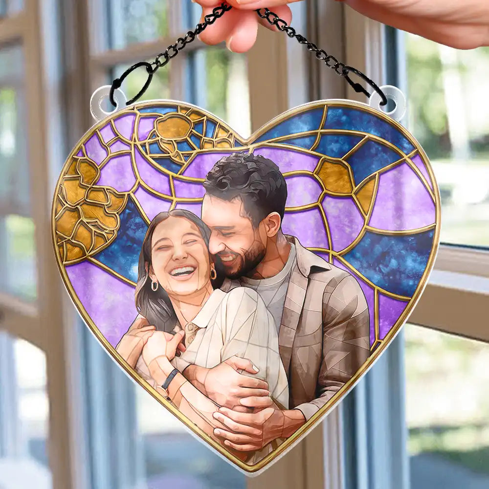 Heart-shaped stained glass style suncatcher with custom photo of a smiling couple, purple and blue with gold accents, hanging by a black chain